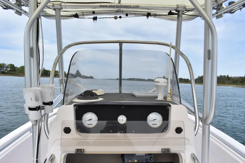 Slide: The Image of 2001 Grady-White Advance 247 boat dashboard with gauges and navigation equipment on calm water. - 25