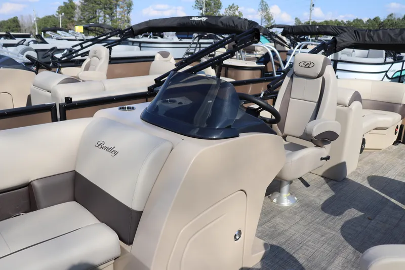 Slide: The Image of 2026 Bentley Pontoons Legacy 223 DL Navigator interior with beige seating and steering console. - 5