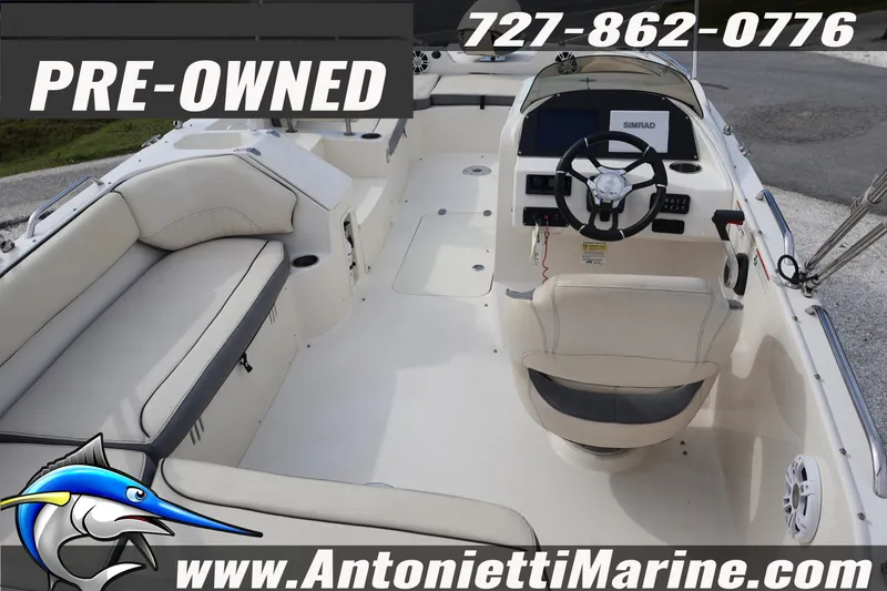 Slide: The Image of Pre-owned 2023 Stingray 212 SC boat interior with seating and steering console. - 11