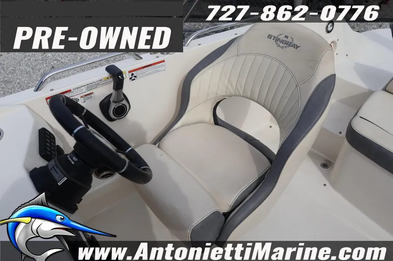 Slide: The Image of Pre-owned 2023 Stingray 212 SC boat interior with steering wheel and seat. - 18