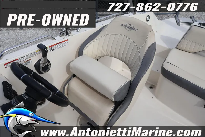 Slide: The Image of Pre-owned 2023 Stingray 212 SC boat interior with steering wheel and seating. - 19