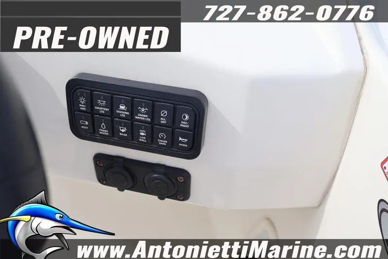 Slide: The Image of Pre-owned 2023 Stingray 212 SC boat control panel with various switches. - 23