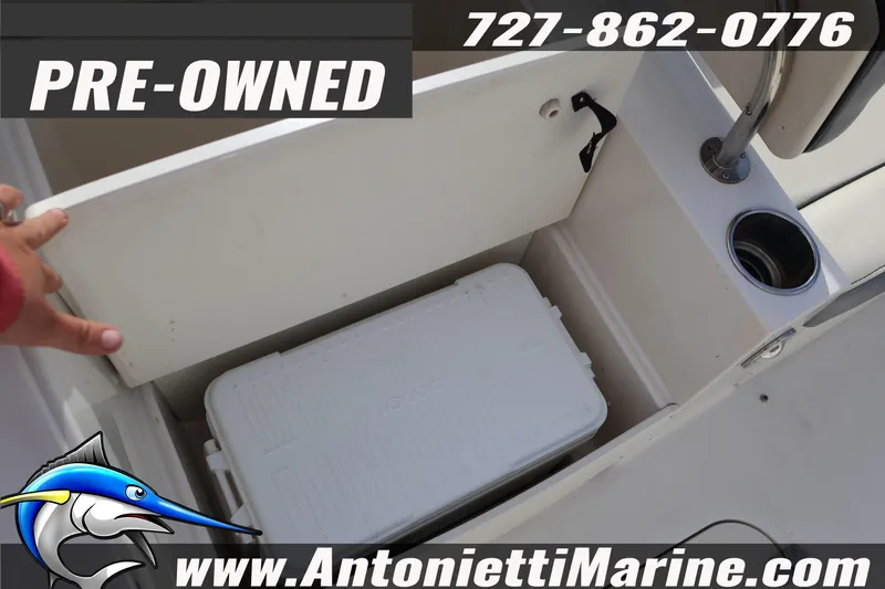 Slide: The Image of Pre-owned 2023 Stingray 212 SC boat storage compartment with cooler and cup holder. - 30