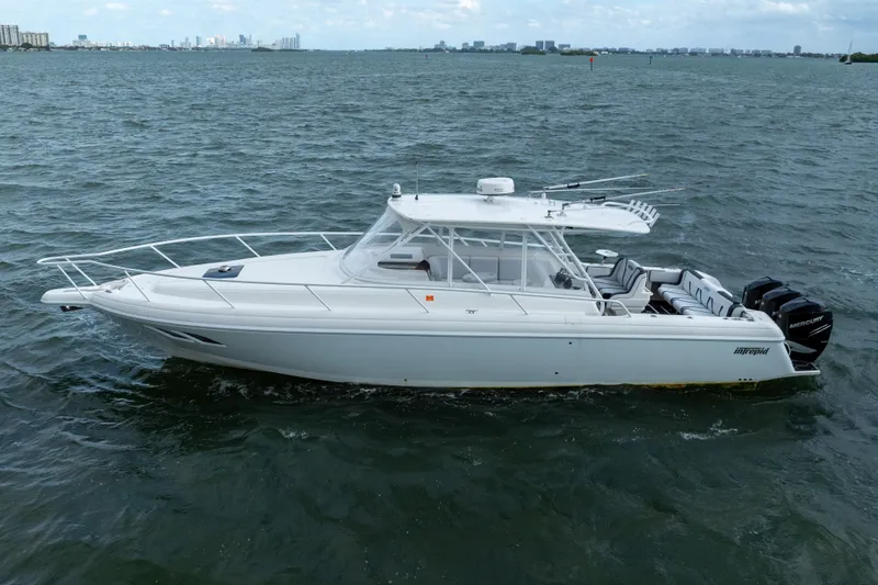Slide: The Image of 2008 Intrepid 390 Sport Yacht cruising on open water, city skyline in background. - 10