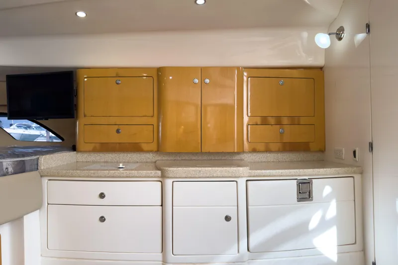 Slide: The Image of 2008 Intrepid 390 Sport Yacht interior with wooden cabinets and modern amenities. - 20