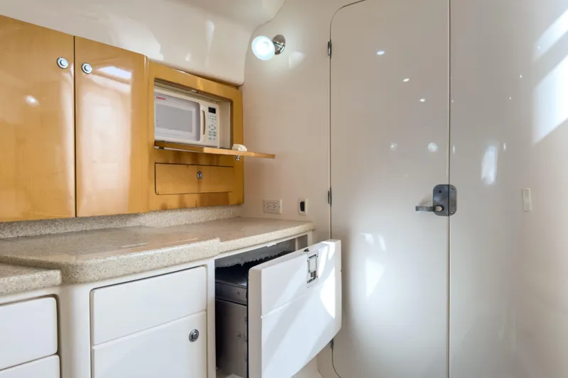 Slide: The Image of 2008 Intrepid 390 Sport Yacht interior kitchen with microwave and storage cabinets. - 21
