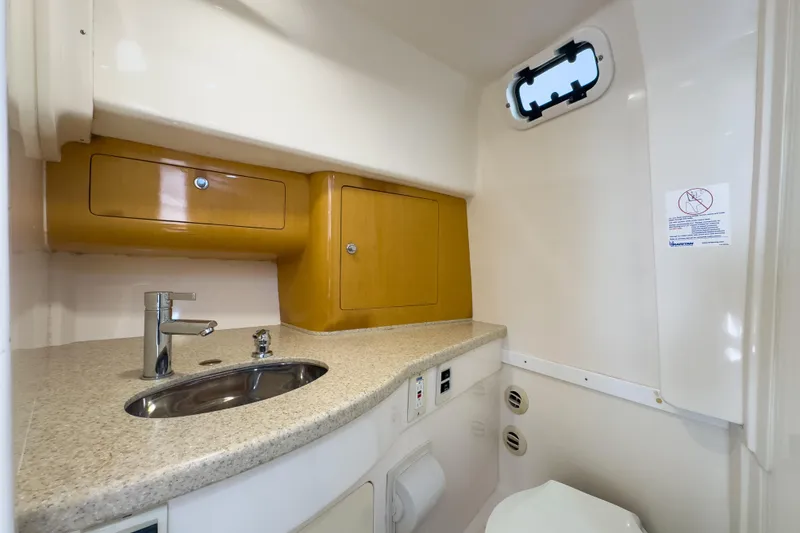 Slide: The Image of 2008 Intrepid 390 Sport Yacht bathroom with sink, storage cabinets, and porthole window. - 24