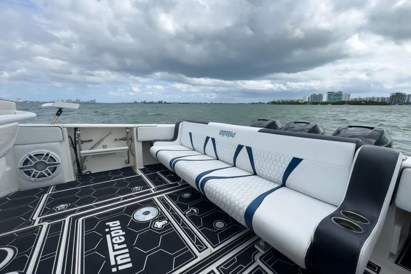 Slide: The Image of 2008 Intrepid 390 Sport Yacht interior with seating, ocean view, and cloudy sky. - 30