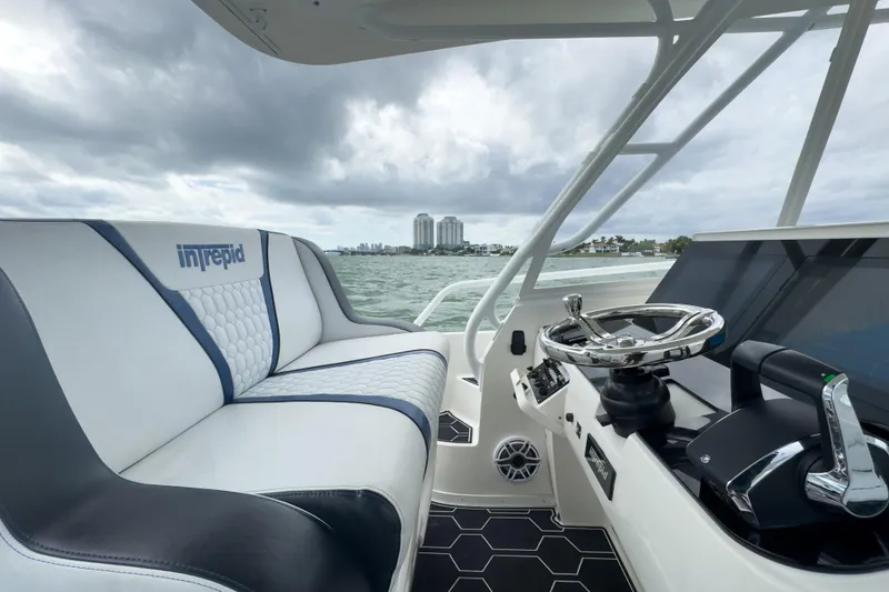 Slide: The Image of 2008 Intrepid 390 Sport Yacht interior with steering wheel and seating, overlooking ocean view. - 34