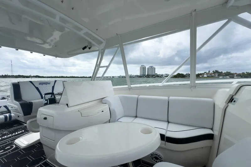 Slide: The Image of 2008 Intrepid 390 Sport Yacht interior with seating and table, overlooking waterfront skyline. - 38