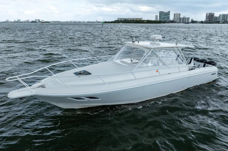 Slide: The Image of 2008 Intrepid 390 Sport Yacht cruising on choppy waters near a city skyline. - 5