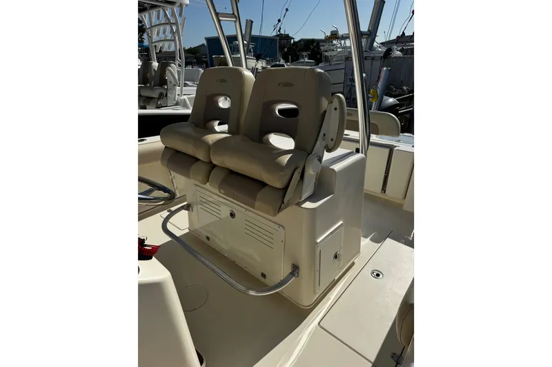 Slide: The Image of 2016 Cobia 296 Center Console boat with dual cushioned seats and storage compartment. - 10