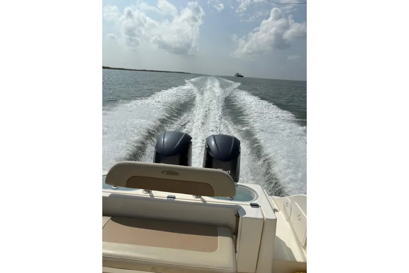 Slide: The Image of 2016 Cobia 296 Center Console boat cruising on open water, leaving a wake behind. - 15