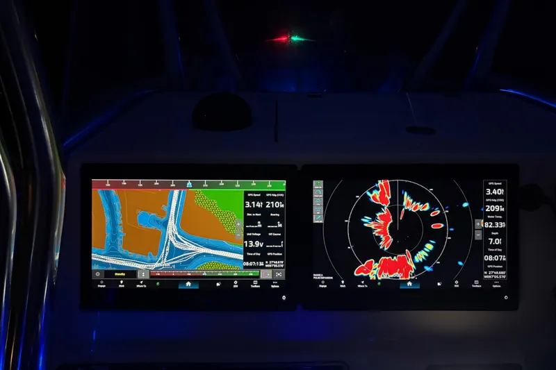 Slide: The Image of Navigation screens on a 2016 Cobia 296 Center Console boat at night. - 16