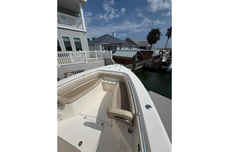 Slide: The Image of 2016 Cobia 296 Center Console boat docked near waterfront homes under a blue sky. - 18