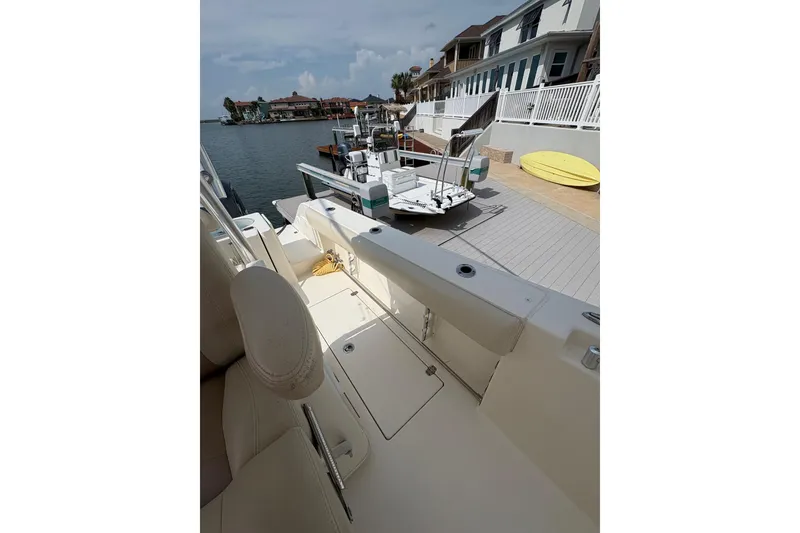 Slide: The Image of 2016 Cobia 296 Center Console boat docked near waterfront homes. - 21