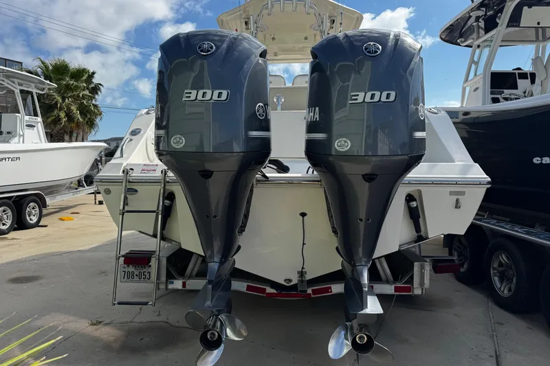 Slide: The Image of 2016 Cobia 296 Center Console with dual Yamaha 300 engines, docked outdoors. - 4