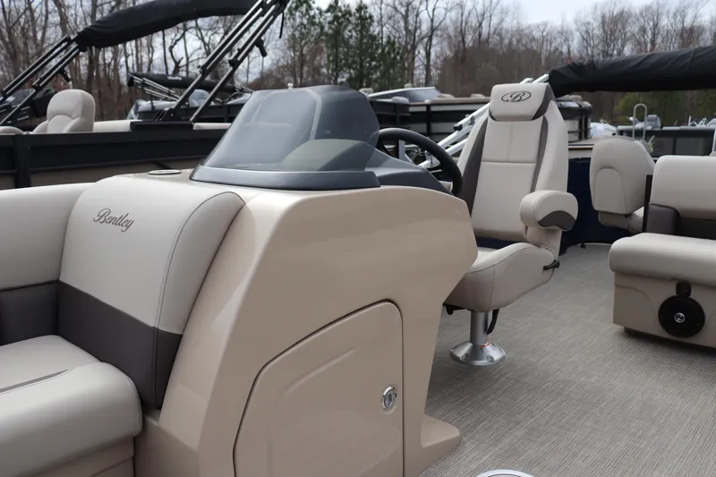 Slide: The Image of 2026 Bentley Pontoons Legacy 223 Fish N Cruise interior with beige seating and steering console. - 4