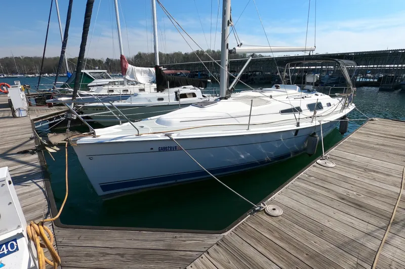The Image of 2006 Hunter 33 sailboat docked at marina, clear sky, calm water. - 0
