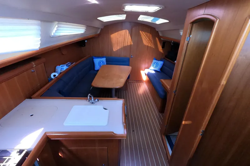Slide: The Image of Interior of 2006 Hunter 33 sailboat with wooden finish and cozy seating area. - 12