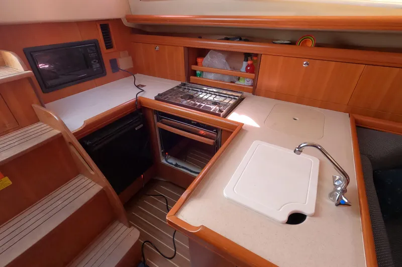 Slide: The Image of Compact kitchen area in a 2006 Hunter 33 sailboat with stove, sink, and storage. - 15
