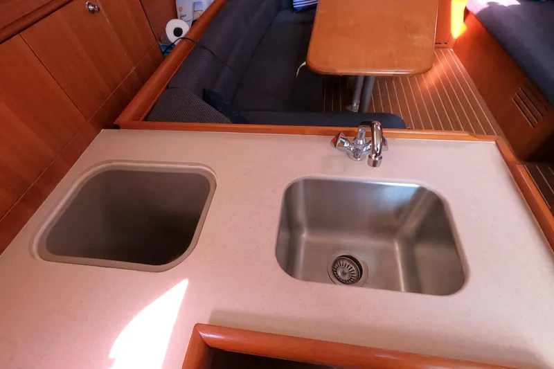 Slide: The Image of Interior of 2006 Hunter 33 yacht showing kitchen sink and dining area. - 16