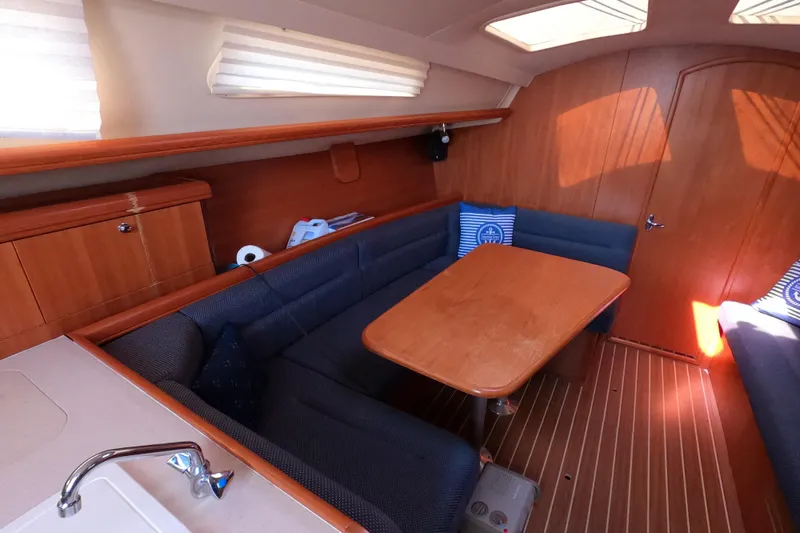 Slide: The Image of Interior of 2006 Hunter 33 sailboat with wooden table and blue seating. - 18