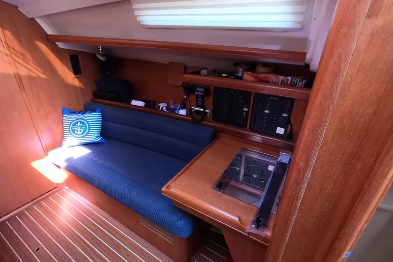 Slide: The Image of Interior of a 2006 Hunter 33 sailboat with blue seating and navigation station. - 19
