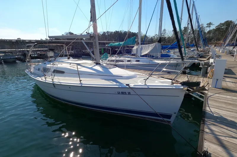 Slide: The Image of 2006 Hunter 33 sailboat docked at marina, surrounded by other boats. - 2