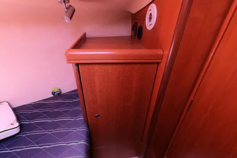 Slide: The Image of Interior cabin of a 2006 Hunter 33 sailboat with wooden cabinetry and bed. - 24
