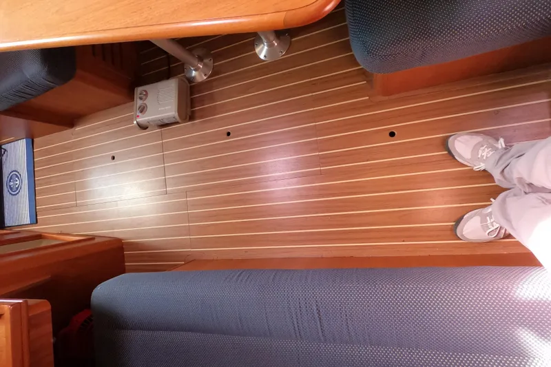 Slide: The Image of Interior of a 2006 Hunter 33 sailboat with wooden flooring and seating. - 26