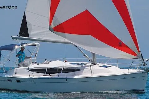 Slide: The Image of 2006 Hunter 33 sailboat with red and white sails on open water. - 35