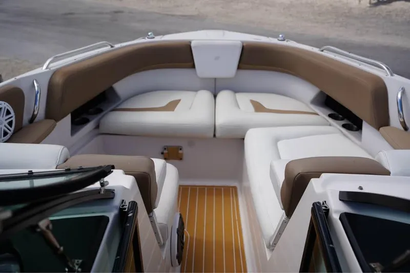 Slide: The Image of 2015 Four Winns H290 boat interior with cushioned seating and wood-style flooring. - 10