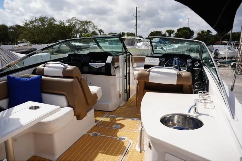 Slide: The Image of 2015 Four Winns H290 boat interior with seating, helm, and sink. - 11