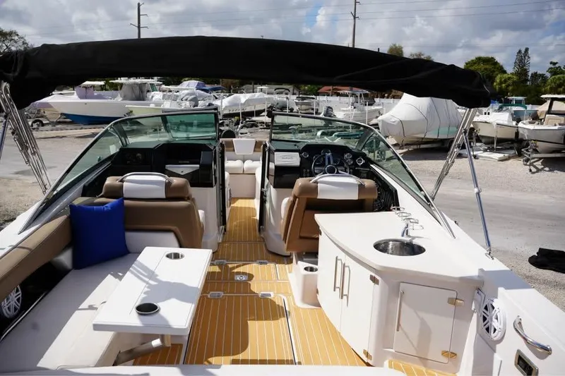 Slide: The Image of 2015 Four Winns H290 boat interior with seating, sink, and steering console. - 18