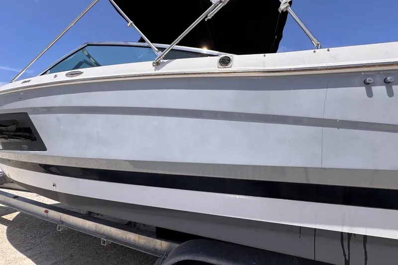 Slide: The Image of 2015 Four Winns H290 boat on trailer under clear blue sky. - 22