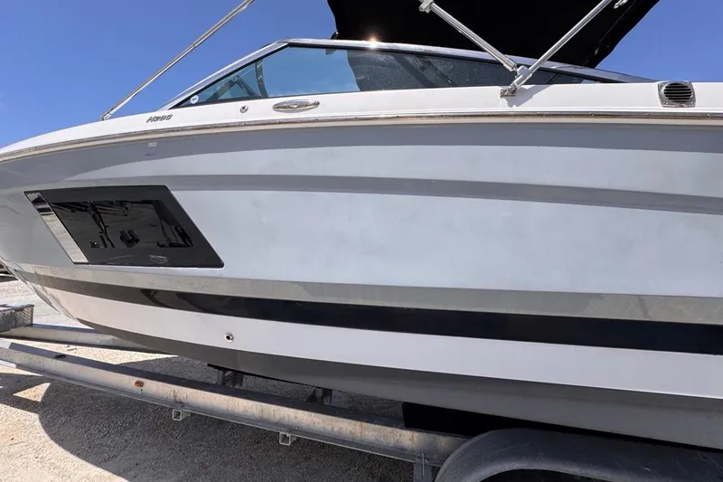 Slide: The Image of 2015 Four Winns H290 boat on trailer under clear blue sky. - 23