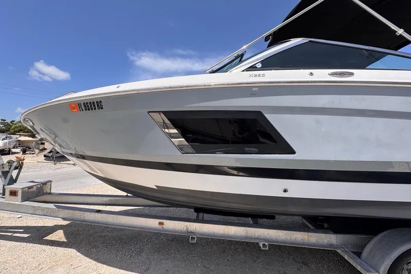 Slide: The Image of 2015 Four Winns H290 boat on trailer under clear blue sky. - 24