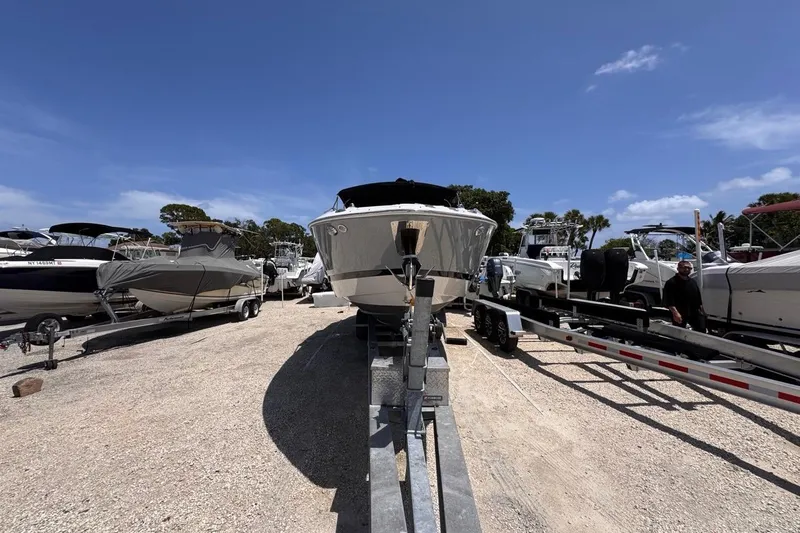 Slide: The Image of 2015 Four Winns H290 boat on trailer in sunny outdoor storage area. - 27