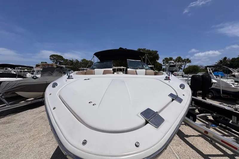 Slide: The Image of 2015 Four Winns H290 boat on trailer under clear blue sky. - 29