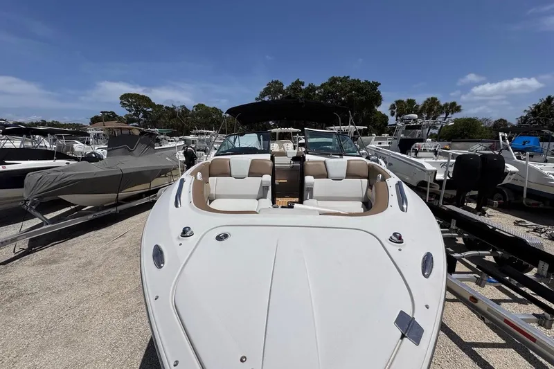 Slide: The Image of 2015 Four Winns H290 boat on trailer, surrounded by other boats, under clear blue sky. - 30