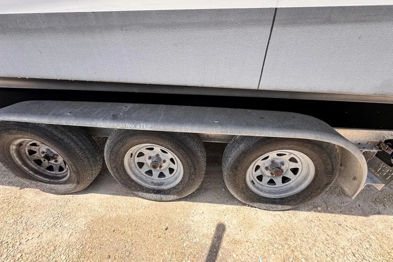 Slide: The Image of Triple-axle trailer for 2015 Four Winns H290 boat on gravel surface. - 38