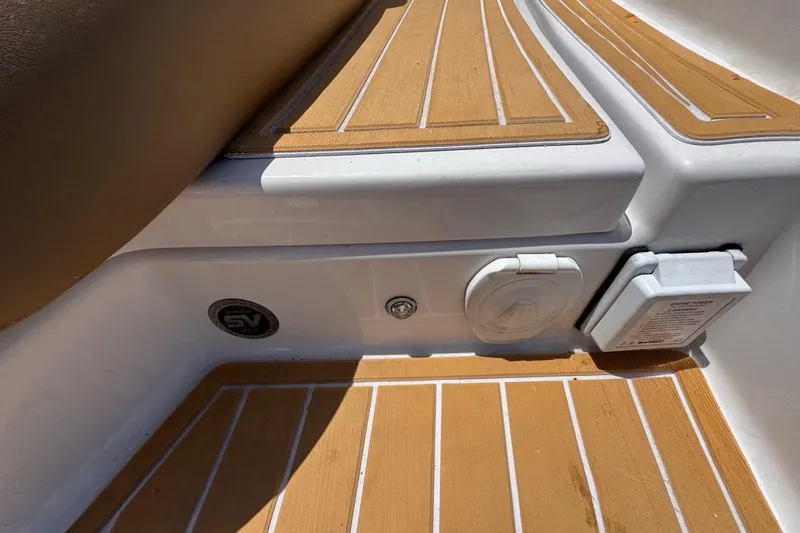 Slide: The Image of 2015 Four Winns H290 boat deck with teak-style flooring and utility access panel. - 44