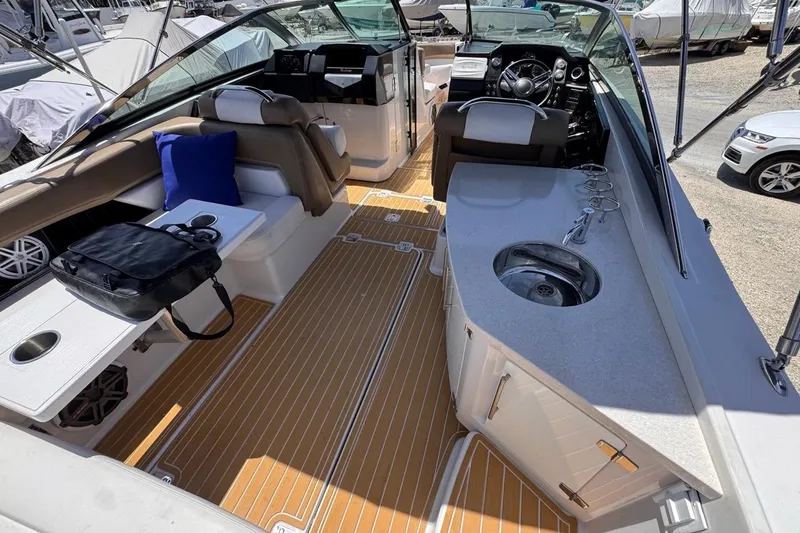 Slide: The Image of 2015 Four Winns H290 boat interior with seating, sink, and steering console. - 46