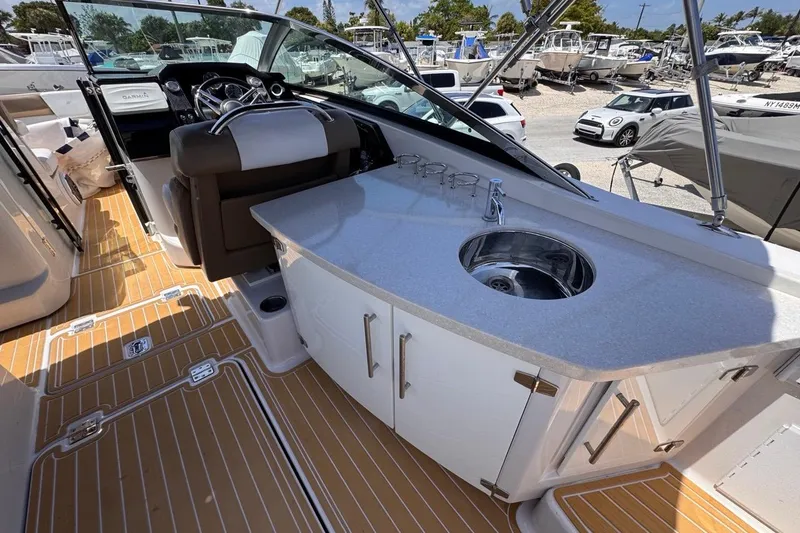 Slide: The Image of 2015 Four Winns H290 boat interior with sink and steering wheel. - 48