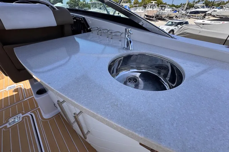 Slide: The Image of 2015 Four Winns H290 boat interior with sleek countertop and built-in sink. - 49