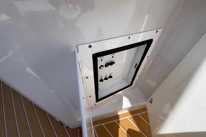 Slide: The Image of Control panel on a 2015 Four Winns H290 boat, featuring a sleek design and wood flooring. - 50