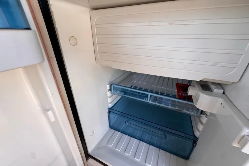 Slide: The Image of Interior view of a Four Winns H290 2015 boat refrigerator, featuring shelves and storage compartments. - 54