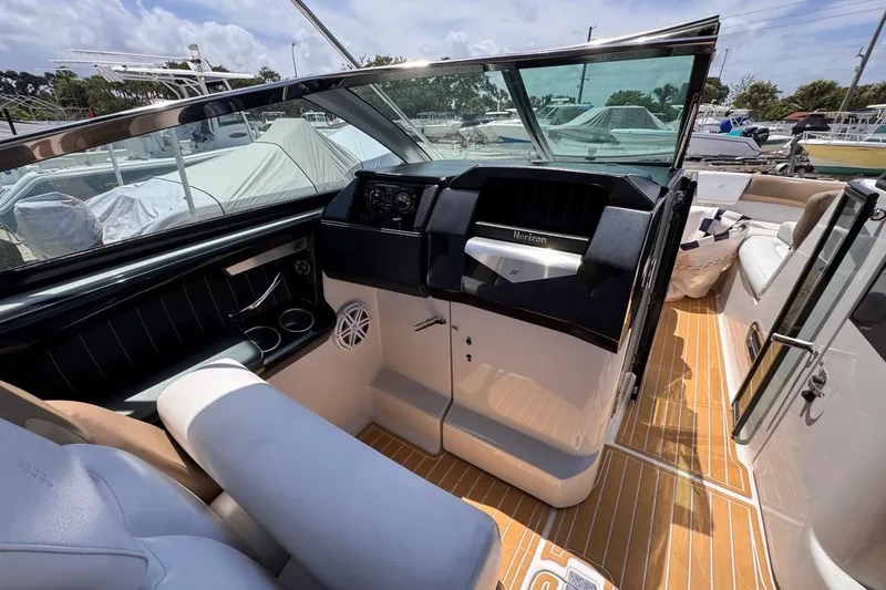 Slide: The Image of 2015 Four Winns H290 boat interior with helm, seating, and wood-style flooring. - 58