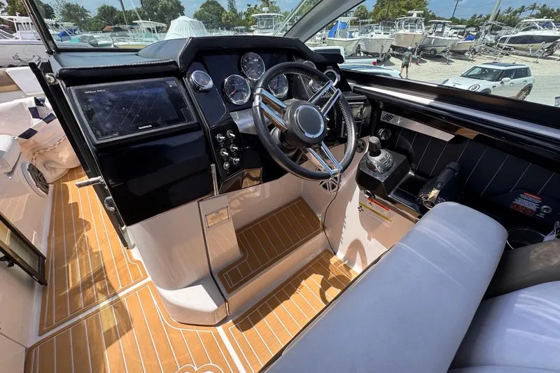 Slide: The Image of Cockpit of 2015 Four Winns H290 boat with modern controls and wooden flooring. - 59